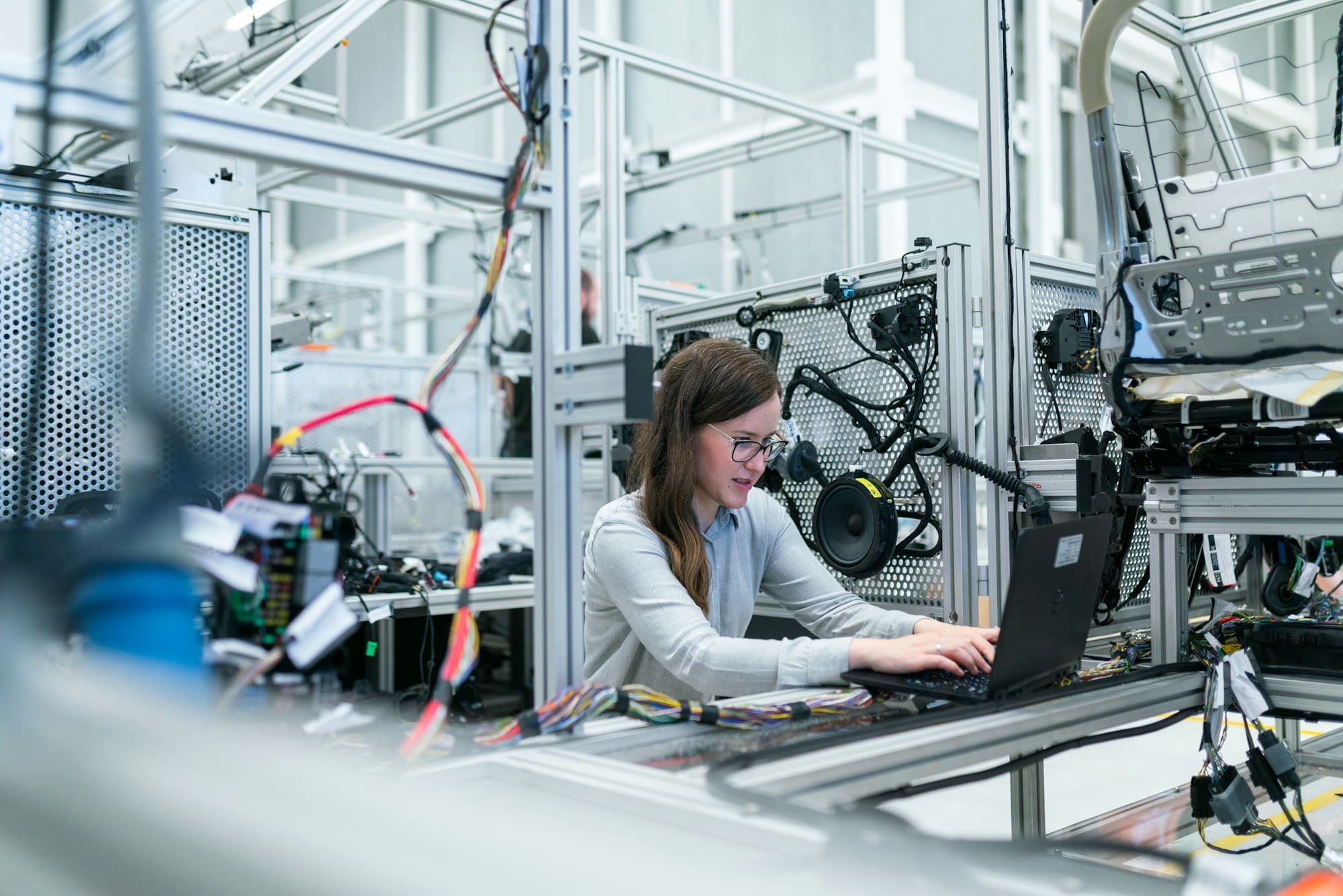 Mitarbeiterin an einer Fertigungsanlage in einem Industriebetrieb