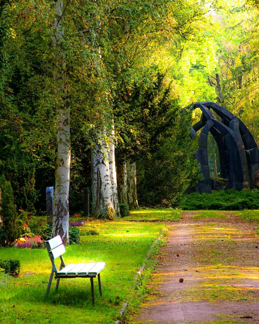 Grüner Stadtpark mit Weg und Parkbank